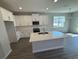 A modern kitchen featuring white cabinets, stainless steel appliances, gray flooring, and a large island at 652 Pothos St, Apopka, FL 32703