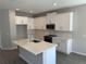 Modern kitchen with an island, stainless steel appliances, and gray wood-look flooring at 652 Pothos St, Apopka, FL 32703