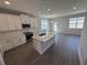Modern kitchen with an island, stainless steel appliances, and gray wood-look flooring at 652 Pothos St, Apopka, FL 32703