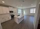 Bright kitchen with white cabinets, quartz countertops, and stainless steel appliances at 652 Pothos St, Apopka, FL 32703