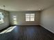 Open living room with wood-look tile flooring and lots of natural light from windows at 652 Pothos St, Apopka, FL 32703