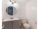 Bathroom with a modern vanity, round mirror, and toilet at 7336 Daniel Webster Dr # 9, Winter Park, FL 32792