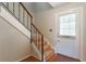 View of the condo entryway featuring carpeted stairs, wooden handrail, and white entry door with window at 7336 Daniel Webster Dr # 9, Winter Park, FL 32792
