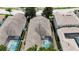 Aerial view of a home with a screened-in pool, mature trees, a well-maintained roof, and lush landscaping at 7415 Devereaux St, Reunion, FL 34747