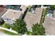 Aerial view showcasing a home with a screened pool, mature trees, and manicured landscaping at 7415 Devereaux St, Reunion, FL 34747