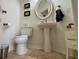 Compact bathroom with a pedestal sink, oval mirror, and tile flooring at 7415 Devereaux St, Reunion, FL 34747