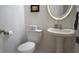 Cozy bathroom featuring a pedestal sink, toilet, and decorative mirror at 7415 Devereaux St, Reunion, FL 34747