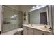 Bathroom featuring a shower/tub combo, double sink vanity, and large mirror at 7415 Devereaux St, Reunion, FL 34747