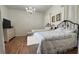 Bright bedroom with hardwood floor features two beds with floral bedding, dresser and hanging chandelier at 7415 Devereaux St, Reunion, FL 34747