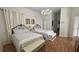 Bright bedroom with hardwood floor features two beds with floral bedding, storage bench, and hanging chandelier at 7415 Devereaux St, Reunion, FL 34747