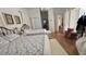 Bright bedroom with hardwood floor features two beds with floral bedding, storage bench, and hanging chandelier at 7415 Devereaux St, Reunion, FL 34747