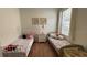 Bright bedroom with hardwood floor features two twin beds with floral bedding, and window at 7415 Devereaux St, Reunion, FL 34747