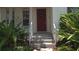 Charming entryway with a red door, decorative wreath, and fresh landscaping at 7415 Devereaux St, Reunion, FL 34747