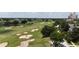 Scenic view of a well-maintained golf course with sand traps and lush green fairways and community buildings at 7415 Devereaux St, Reunion, FL 34747