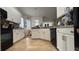 Well-lit kitchen featuring ample white cabinetry, tile flooring, and modern black appliances at 7415 Devereaux St, Reunion, FL 34747