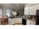 Bright kitchen showcasing white cabinetry, laminate countertops, and a black dishwasher at 7415 Devereaux St, Reunion, FL 34747