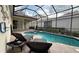 Relaxing screened-in pool area with comfortable lounge chairs and a beautiful view of the surrounding landscape at 7415 Devereaux St, Reunion, FL 34747