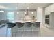 Modern kitchen boasts a large island with seating, stainless steel appliances and bright white cabinetry at 756 Pointe Emerson Blvd, Apopka, FL 32703