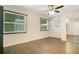 Bright bedroom features wood-look floors, large windows, ceiling fan, and a closet with mirrored sliding doors at 821 Sutter Loop, Longwood, FL 32750