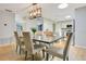 Dining area showcases a rustic table, chandelier lighting, and seamless flow to a modern kitchen at 821 Sutter Loop, Longwood, FL 32750