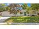 Charming one-story home with a well-manicured lawn, a teal door, and an attached two-car garage at 821 Sutter Loop, Longwood, FL 32750