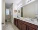 Bright bathroom featuring double sinks, vanity with cabinet storage, and a large mirror, creating a functional space at 9007 Pelican Cove Trce, Kissimmee, FL 34747
