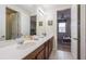 Double vanity bathroom connecting to a bedroom with modern decor and another bedroom at 9007 Pelican Cove Trce, Kissimmee, FL 34747
