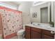 Neutral bathroom featuring a single sink vanity, large mirror, and decorative shower curtain at 9007 Pelican Cove Trce, Kissimmee, FL 34747