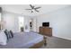 Bright primary bedroom featuring ensuite bath, TV, and ceiling fan at 9007 Pelican Cove Trce, Kissimmee, FL 34747