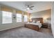 Well-lit bedroom with a ceiling fan, a king-size bed with two nightstands, and large windows at 9007 Pelican Cove Trce, Kissimmee, FL 34747