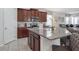 Open-concept kitchen with granite countertops, stainless steel appliances, and island at 9007 Pelican Cove Trce, Kissimmee, FL 34747