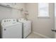 Bright laundry room featuring a full-size white washer and dryer, plus overhead shelving at 9007 Pelican Cove Trce, Kissimmee, FL 34747