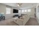 Spacious living room with a large sectional sofa, ceiling fan, and a wall-mounted TV at 9007 Pelican Cove Trce, Kissimmee, FL 34747