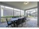 Screened-in patio with dining and lounge seating overlooking pool area at 9007 Pelican Cove Trce, Kissimmee, FL 34747