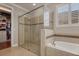 Luxurious bathroom featuring a glass shower, tub with tile accents, and a walk-in closet at 9405 Bordet Ct, Orlando, FL 32827