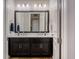 Updated bathroom features a double sink vanity with framed mirror, modern lighting, and neutral color palette at 9405 Bordet Ct, Orlando, FL 32827