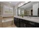 Bathroom featuring a double vanity, a large mirror, and a separate shower and tub at 9405 Bordet Ct, Orlando, FL 32827