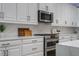 Well-appointed kitchen featuring white cabinets, quartz countertops, and stainless steel appliances at 9405 Bordet Ct, Orlando, FL 32827