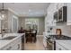 Bright kitchen with white cabinets, quartz countertops, and stainless steel appliances overlooking a dining area at 9405 Bordet Ct, Orlando, FL 32827