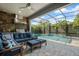 Screened-in patio area with a full outdoor kitchen, comfortable seating, and a pool view at 9405 Bordet Ct, Orlando, FL 32827