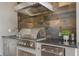 Outdoor kitchen featuring a stainless steel grill, granite counters and stylish tile backsplash at 9405 Bordet Ct, Orlando, FL 32827