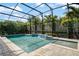 Sparkling screened-in pool with a spillover spa and lush tropical landscaping for privacy at 9405 Bordet Ct, Orlando, FL 32827