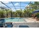 Beautiful screened-in pool area with waterfall feature, lush landscaping and plenty of seating at 9405 Bordet Ct, Orlando, FL 32827