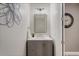Stylish powder room featuring a gray vanity, modern lighting, and decorative mirror at 9405 Bordet Ct, Orlando, FL 32827