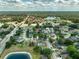 Expansive aerial shot showcases the community, highlighting lush green spaces and the serene lake, with a focus on the property at 115 Oak Grove Cir, Lake Mary, FL 32746