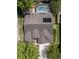 Aerial view of the home, highlighting the roof, solar panel, screened-in pool, backyard and surrounding landscaping at 115 Oak Grove Cir, Lake Mary, FL 32746