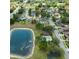 Beautiful aerial view of the property with a pool, a pond, and mature trees in a well-maintained neighborhood at 115 Oak Grove Cir, Lake Mary, FL 32746