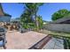Cozy backyard with a brick-paved patio, outdoor seating, a grill, and lush landscaping for privacy and enjoyment at 115 Oak Grove Cir, Lake Mary, FL 32746