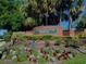 Attractive brick Huntington Ridge community entrance with lush landscaping, flowers and mature palm trees at 115 Oak Grove Cir, Lake Mary, FL 32746
