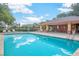 Community pool with plenty of lounge chairs and tables for relaxing and enjoying the sunshine at 115 Oak Grove Cir, Lake Mary, FL 32746